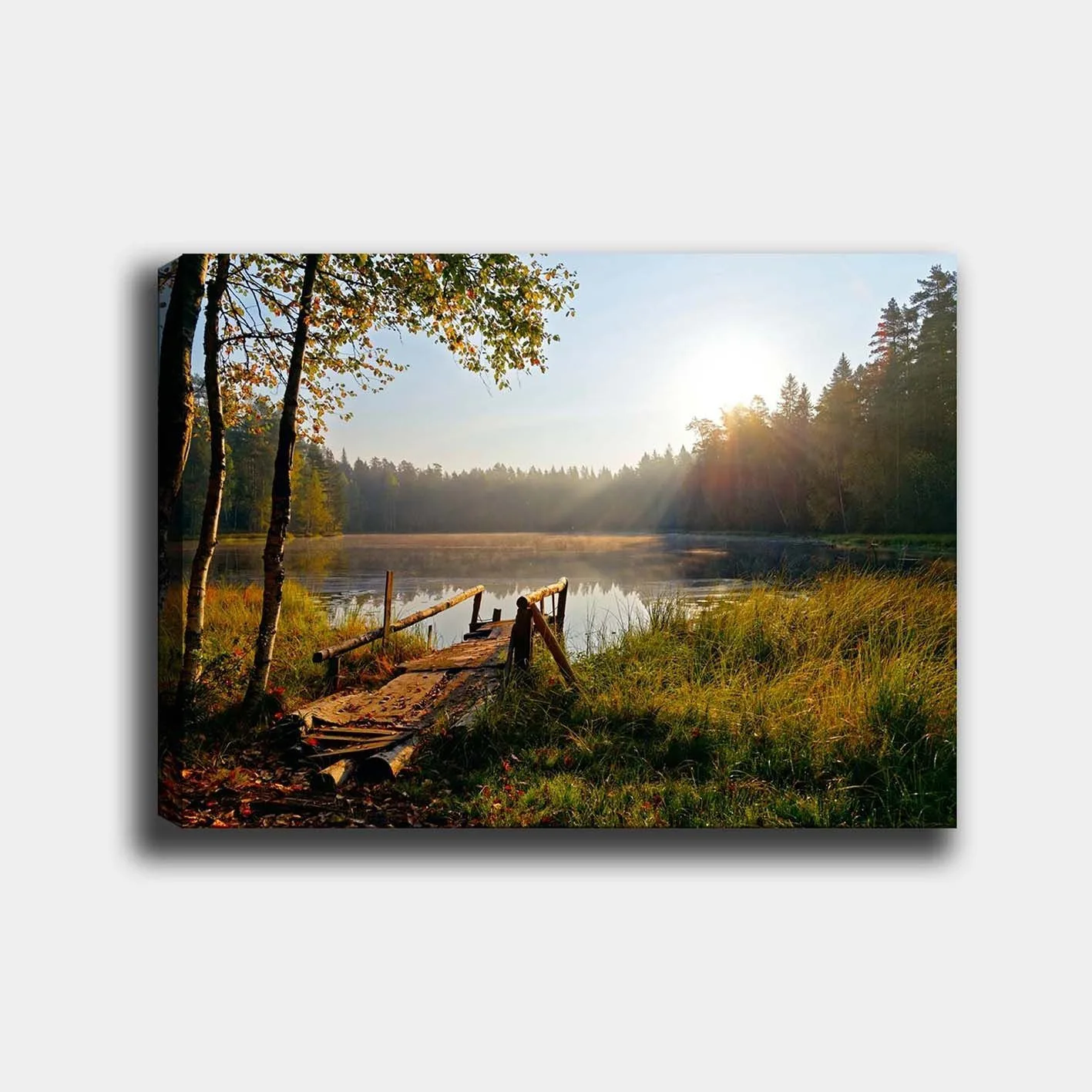 Canvastavla 70x100 cm - Stilla sjö med en träbro omgiven av grönskande träd och morgonsolens strålar - Grön / Brun / Gul